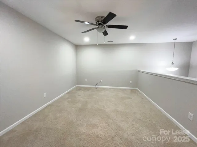 an empty room with a ceiling fan and window