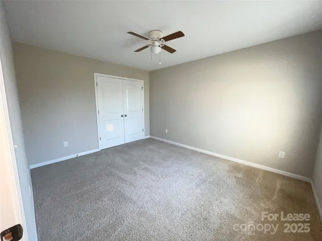 an empty room with a ceiling fan and a window
