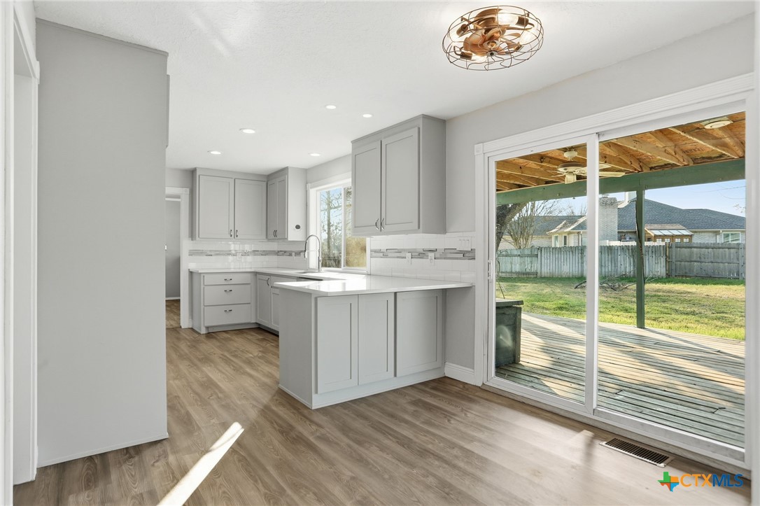 119 Primrose Drive Kyle, TX 78640 - Photo 11 of 30 a kitchen with white cabinets and a large window