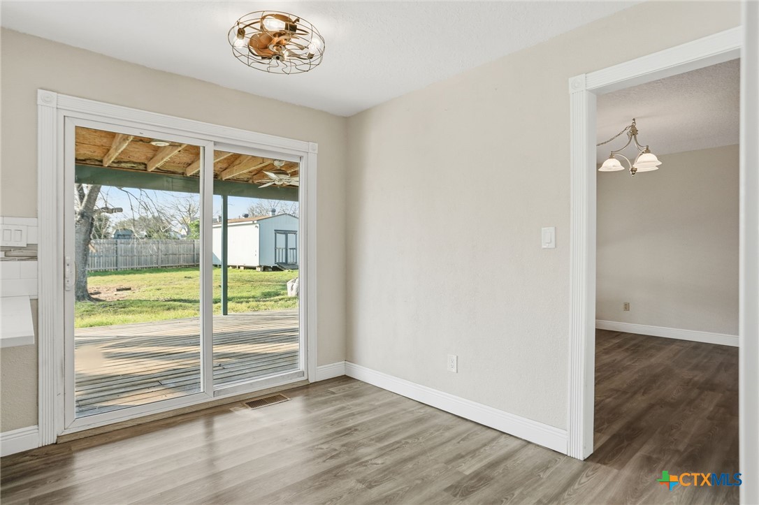 119 Primrose Drive Kyle, TX 78640 - Photo 12 of 30 wooden floor in an empty room with a window