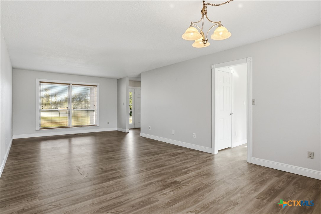 119 Primrose Drive Kyle, TX 78640 - Photo 13 of 30 an empty room with wooden floor and windows