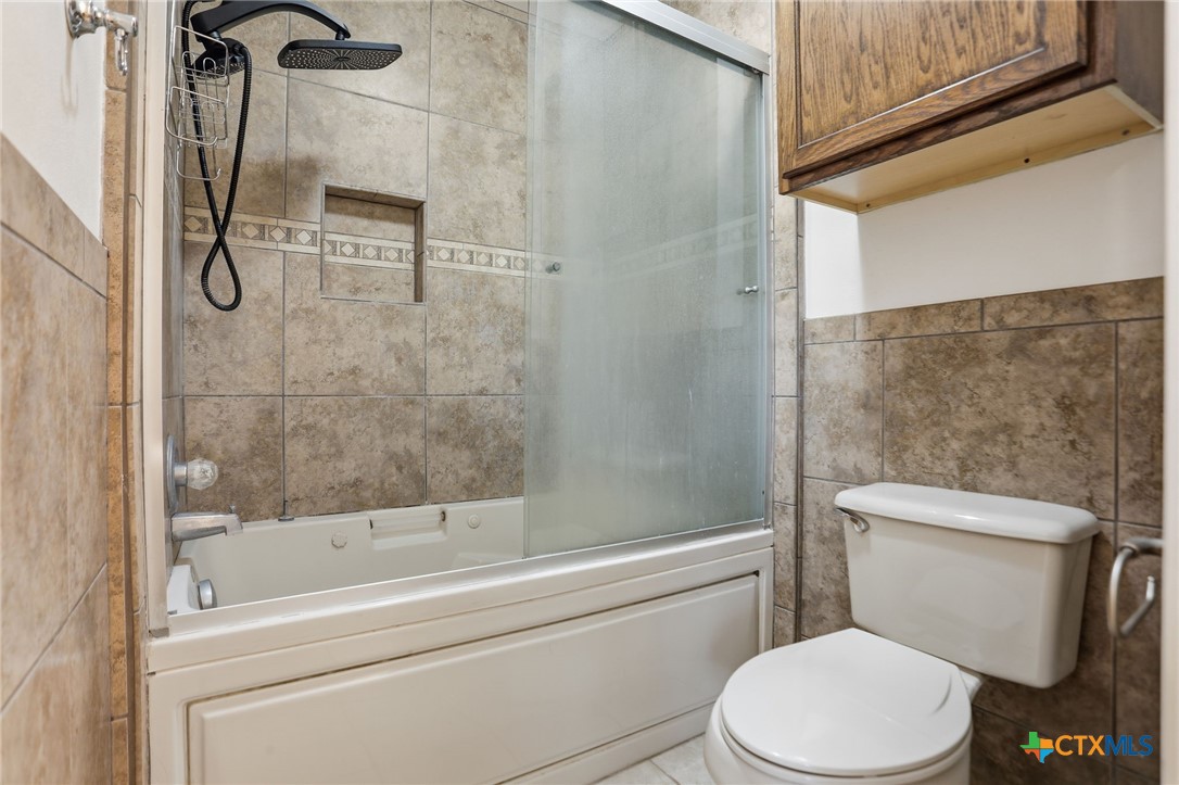119 Primrose Drive Kyle, TX 78640 - Photo 20 of 30 a white toilet sitting next to a bath tub and shower