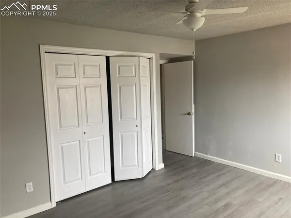 an empty room with wooden floor and closet area