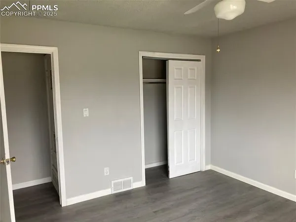 an empty room with wooden floor and closet