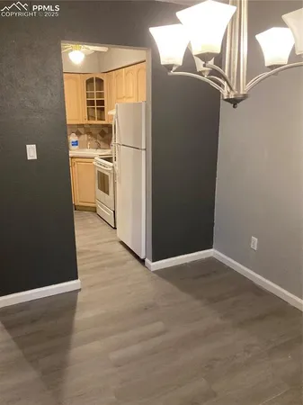 a view of a kitchen with a refrigerator and a stove top oven