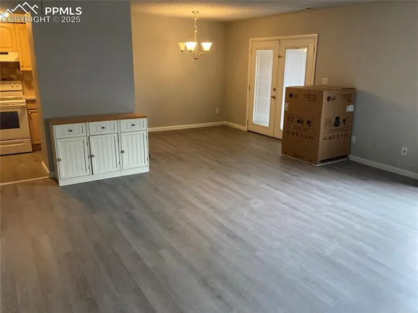 an empty room with wooden floor and cabinet