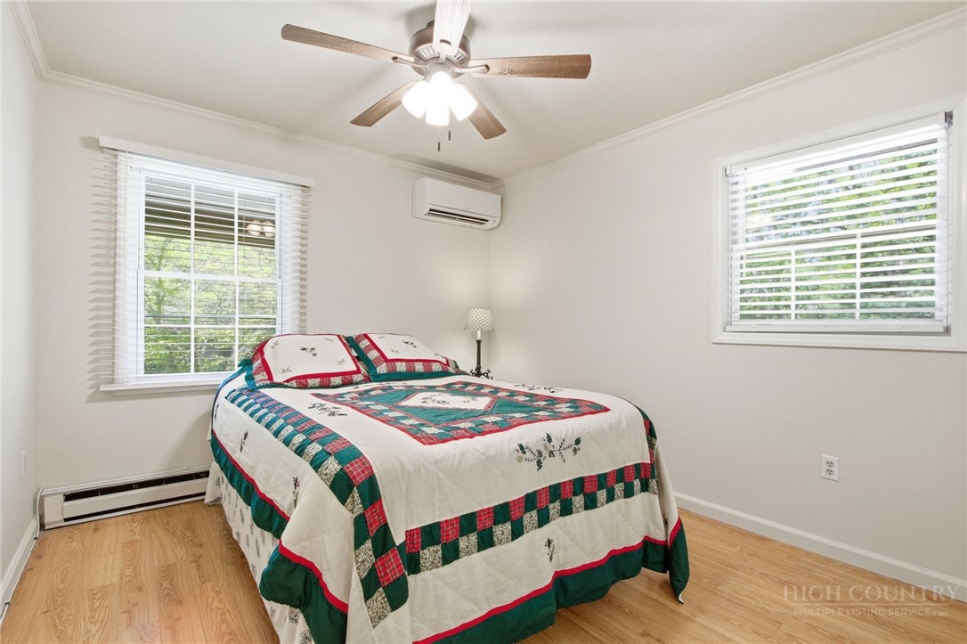 164 Rocky Meadows Road Newland, NC 28657 - Photo 17 of 49 a bedroom with a bed a chandelier and a window