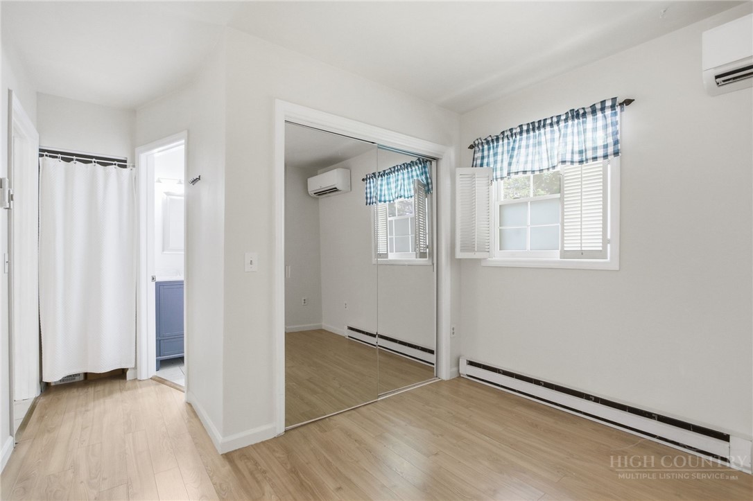 164 Rocky Meadows Road Newland, NC 28657 - Photo 22 of 49 an empty room with wooden floor and a window