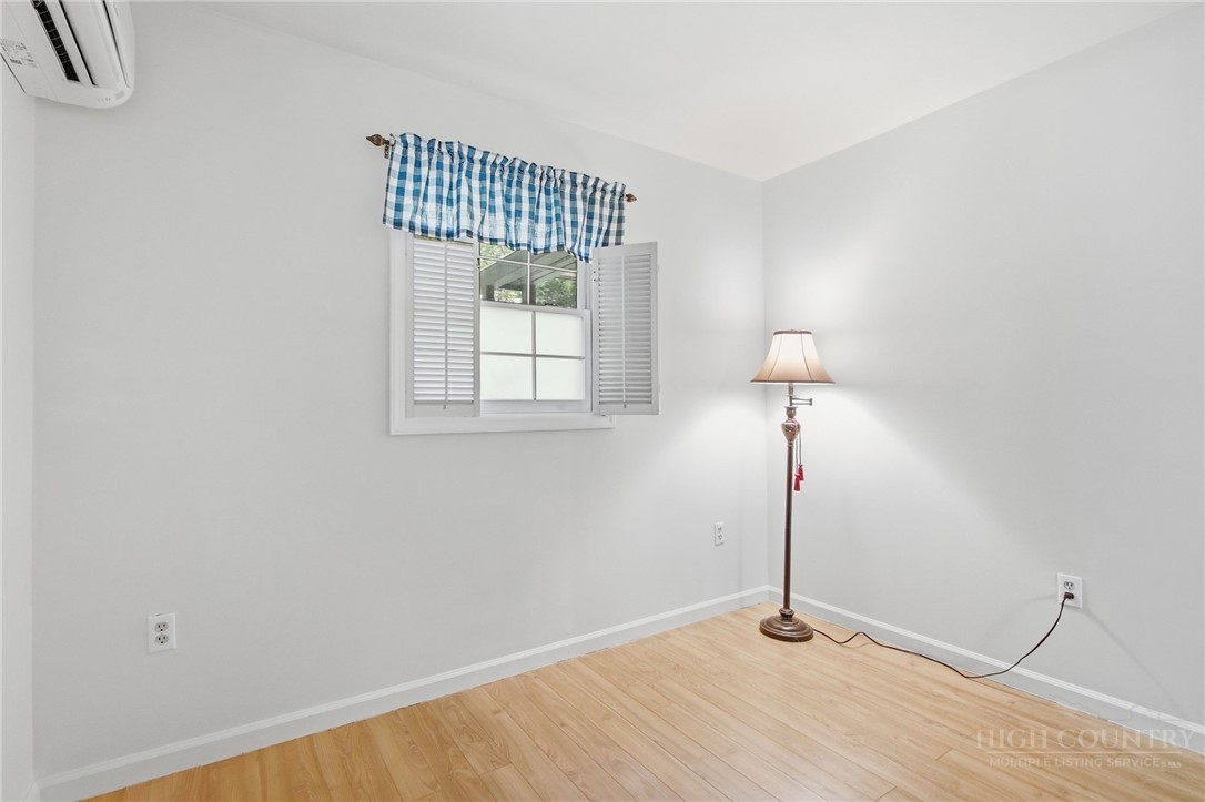 164 Rocky Meadows Road Newland, NC 28657 - Photo 24 of 49 a view of an empty room with chandelier fan and wooden floor