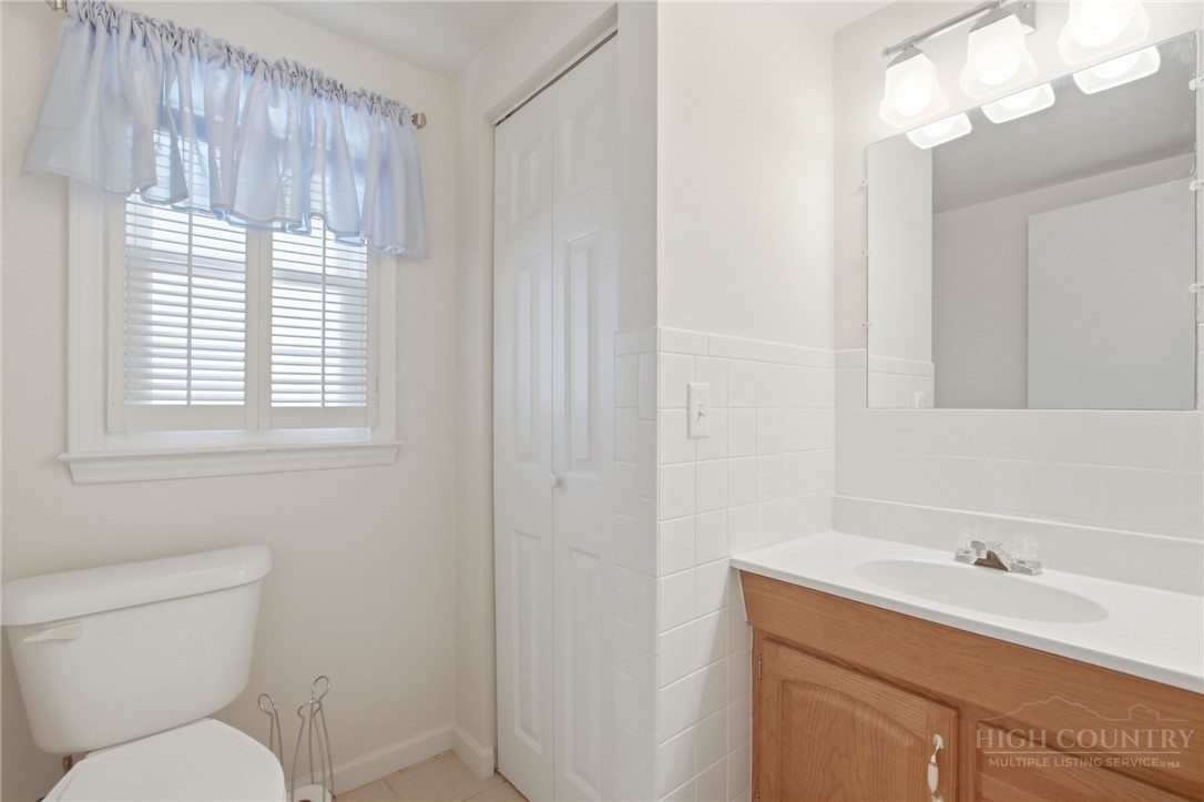 164 Rocky Meadows Road Newland, NC 28657 - Photo 41 of 49 a bathroom with a toilet sink vanity and mirror