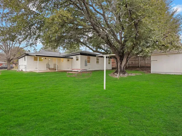 a view of a house with a yard and tree