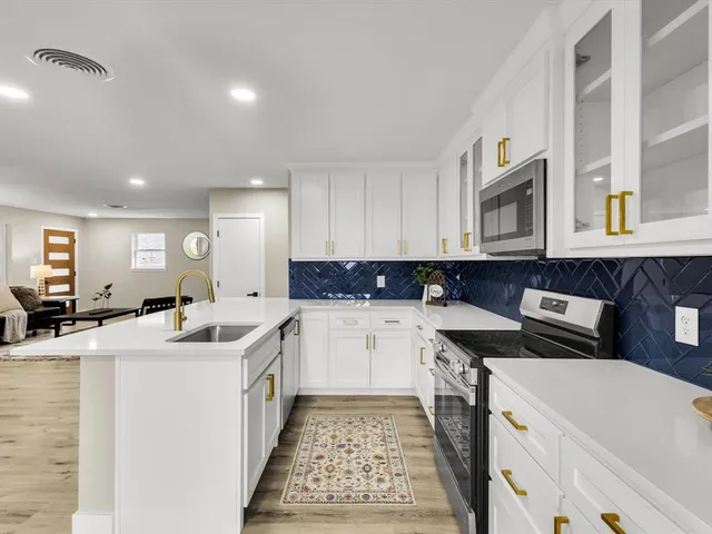 a kitchen with a sink stove and cabinets