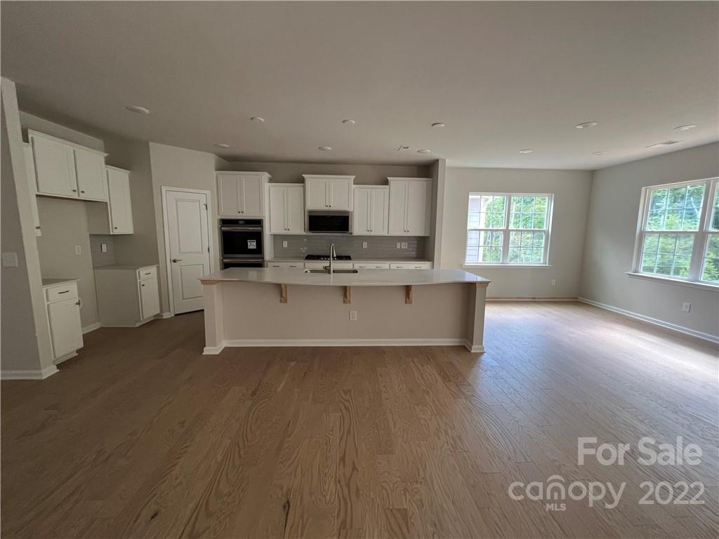 3137 Windhaven Lane, Unit 76 Tega Cay, SC 29708 - Photo 4 of 15 a large kitchen with cabinets table and stainless steel appliances