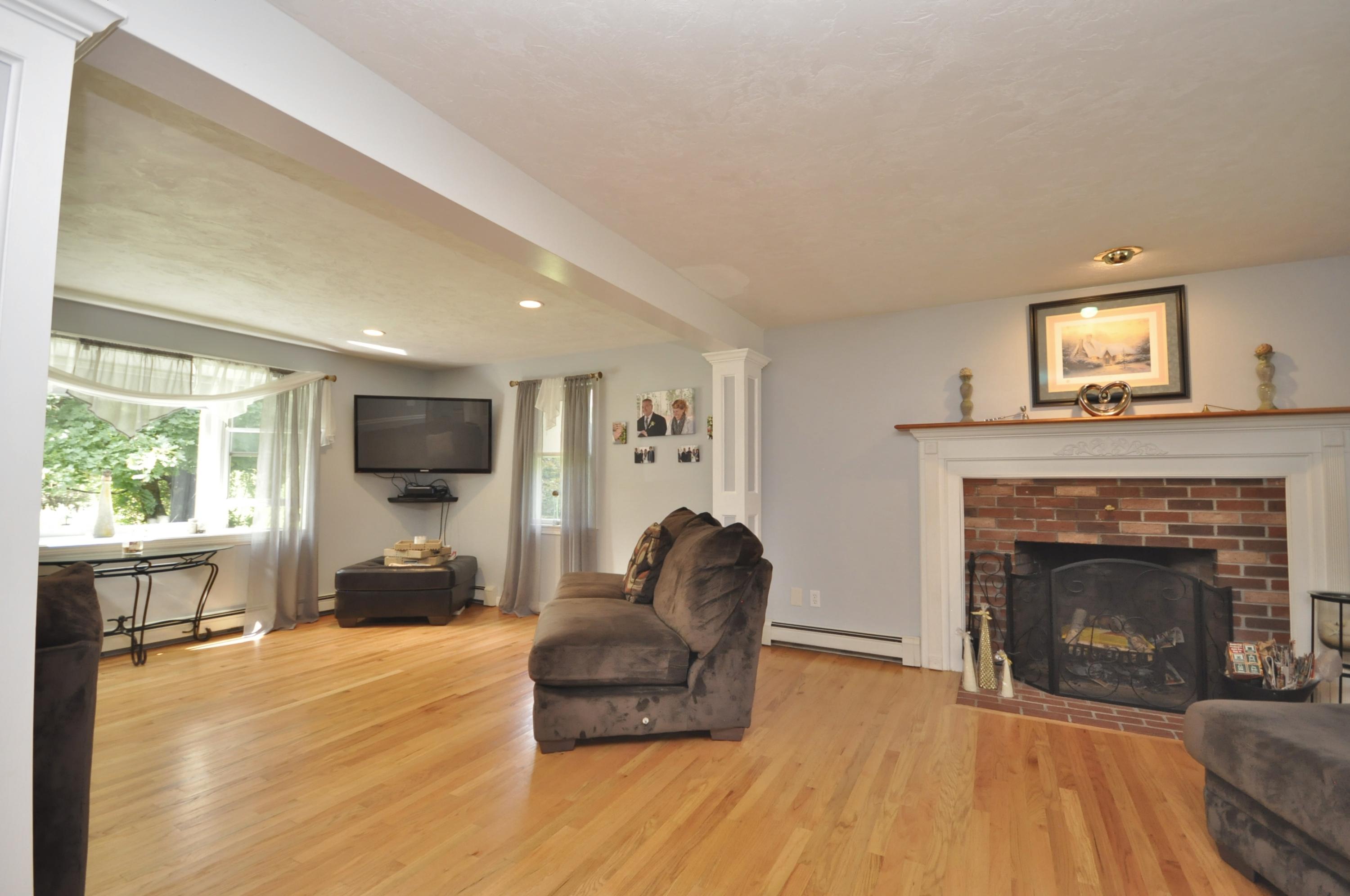 29 Swift Road Sagamore Beach, MA 02562 - Photo 12 of 34 a living room with furniture a flat screen tv and a fireplace