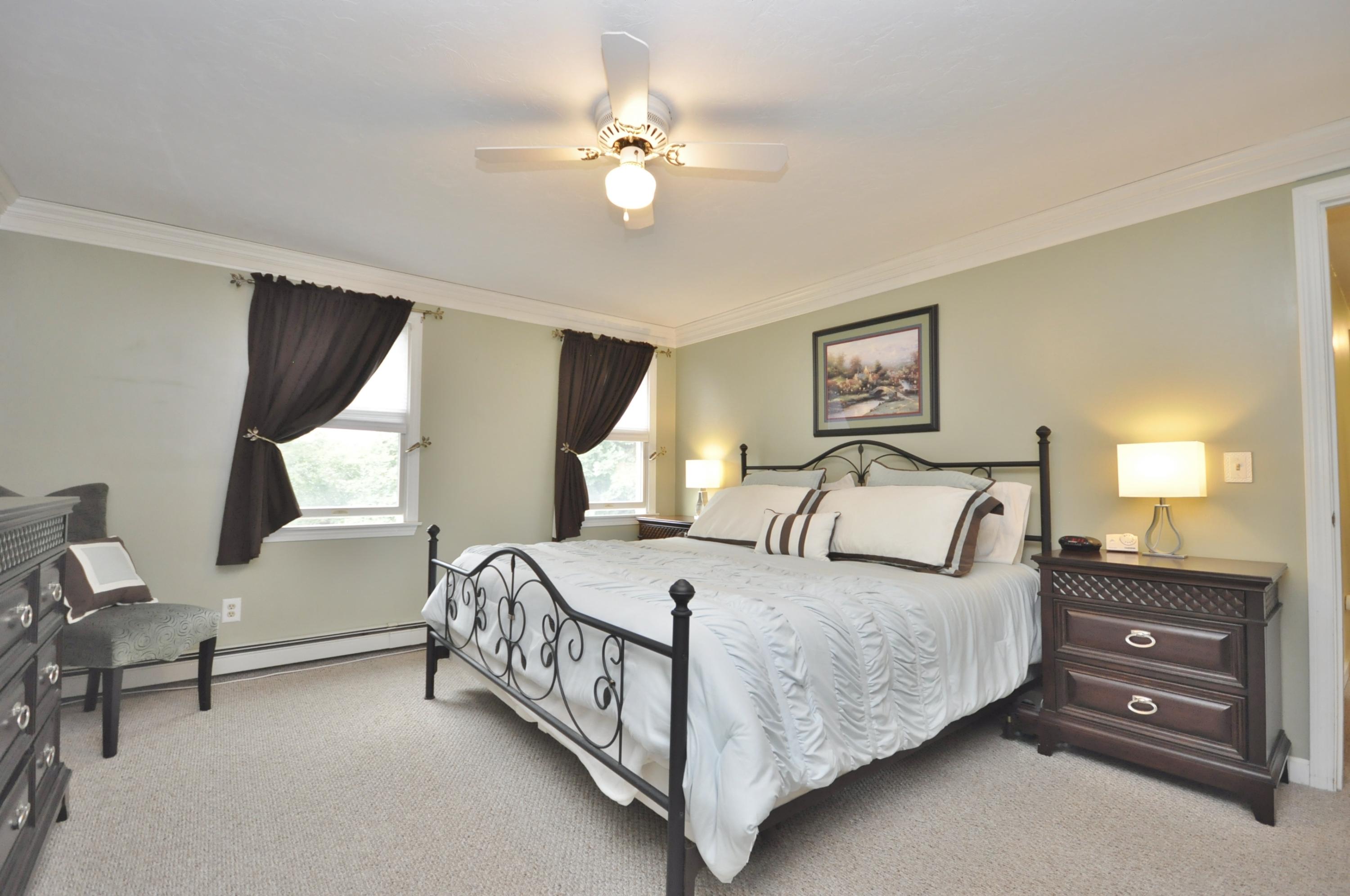 29 Swift Road Sagamore Beach, MA 02562 - Photo 17 of 34 a bedroom with a bed and a chandelier