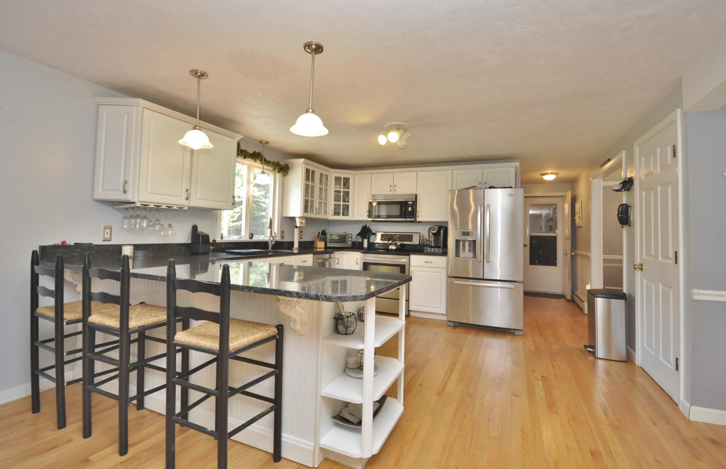 29 Swift Road Sagamore Beach, MA 02562 - Photo 5 of 34 a kitchen with stainless steel appliances a refrigerator a stove top oven and a center island with wooden floor