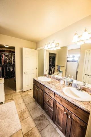 a spacious bathroom with a granite countertop sink and a mirror