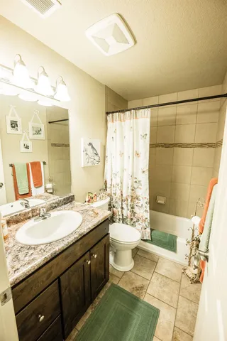 a spacious bathroom with a granite countertop sink and a mirror