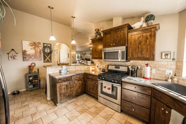 a kitchen with stainless steel appliances granite countertop a stove and cabinets
