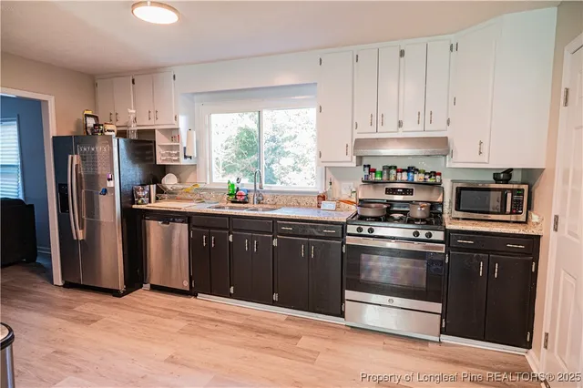a kitchen with stainless steel appliances granite countertop a stove a refrigerator and a sink
