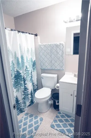 a bathroom with a toilet and a shower curtain