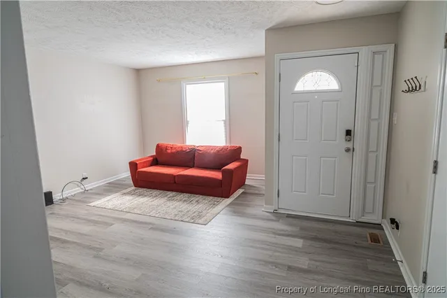 a living room with furniture and a wooden floor