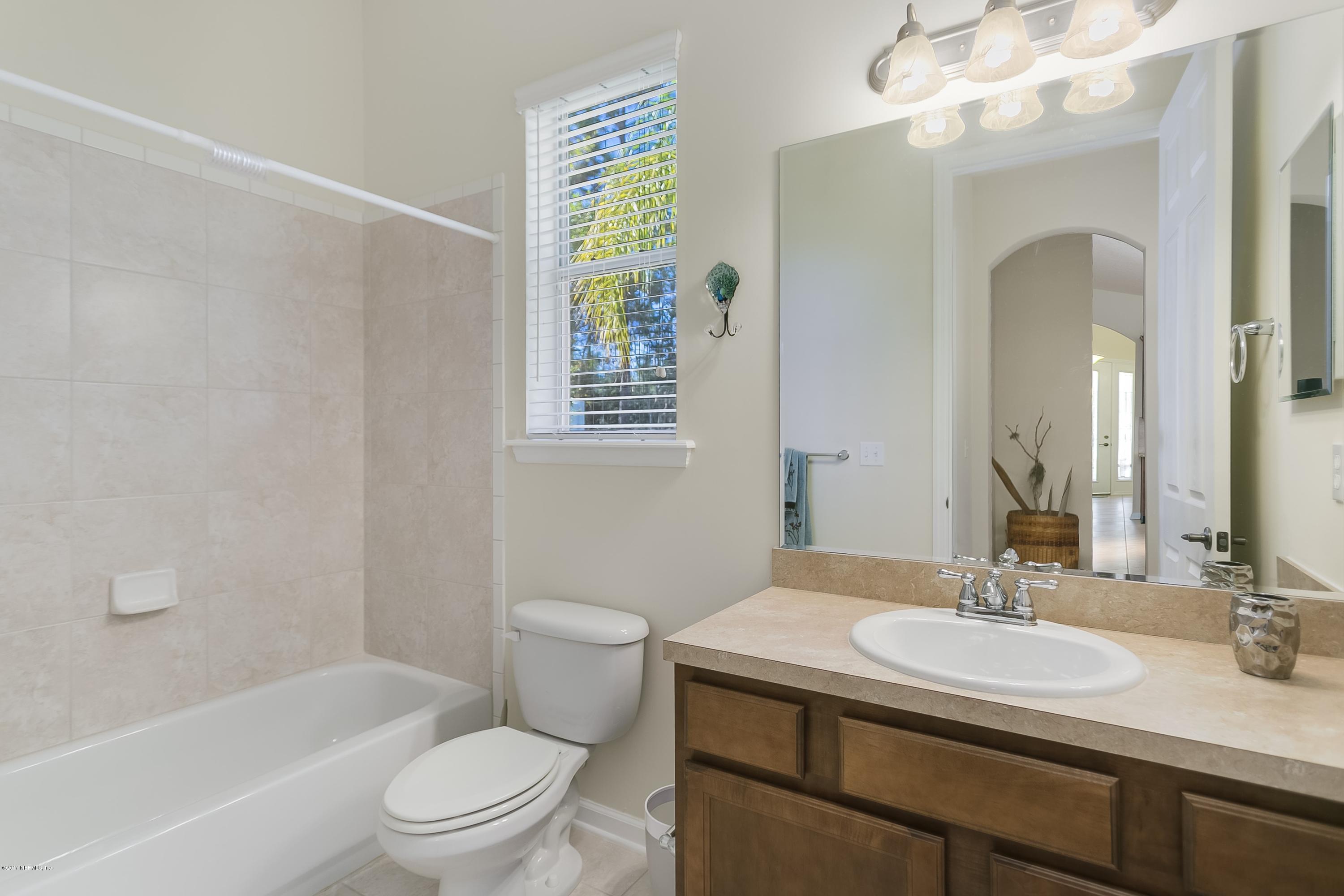 660 Porta Rosa Circle St. Augustine, FL 32092 - Photo 18 of 32 a bathroom with a granite countertop sink a toilet and shower