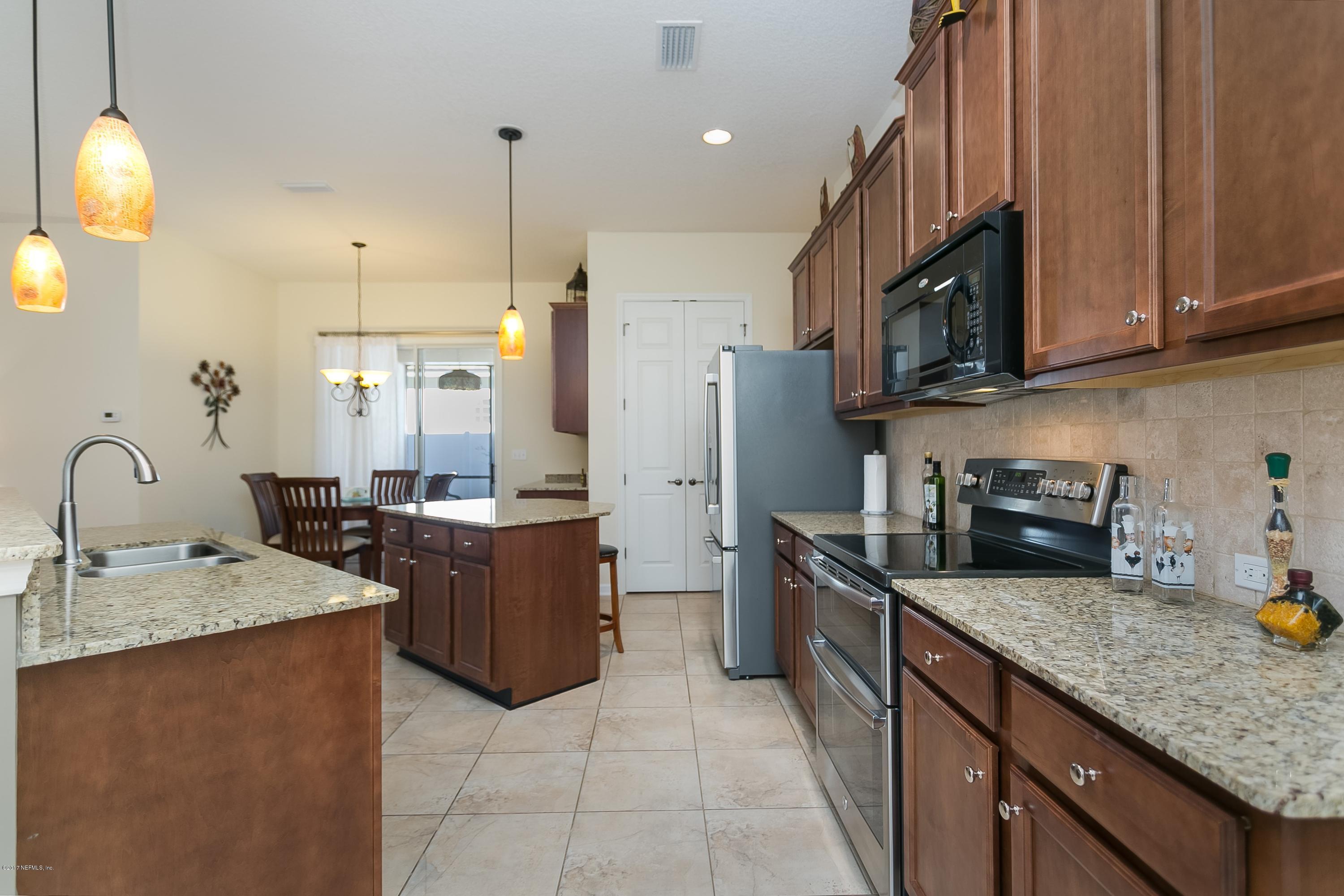 660 Porta Rosa Circle St. Augustine, FL 32092 - Photo 8 of 32 a kitchen with stainless steel appliances granite countertop a sink stove and refrigerator
