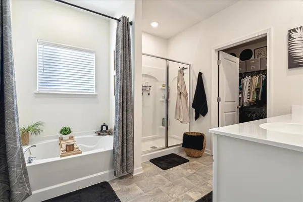 a bathroom with a tub a sink and a window