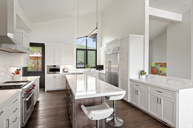 11547 Soaring Hawk Lane Hideout, UT 84036 - Photo 12 of 43 Open-concept kitchen featuring a large central island, white cabinetry, dark wood-finish flooring, stainless steel appliances, and high vaulted ceilings