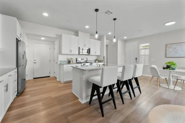 a large kitchen with cabinets table and chairs
