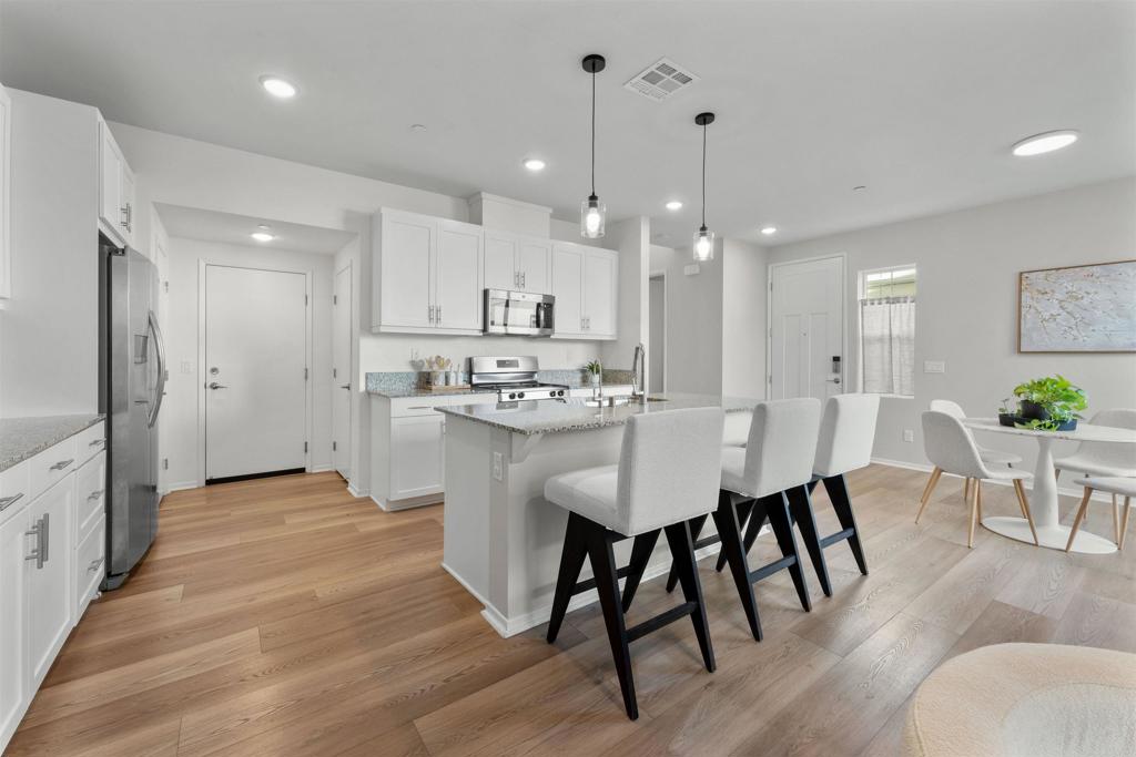 a large kitchen with cabinets table and chairs