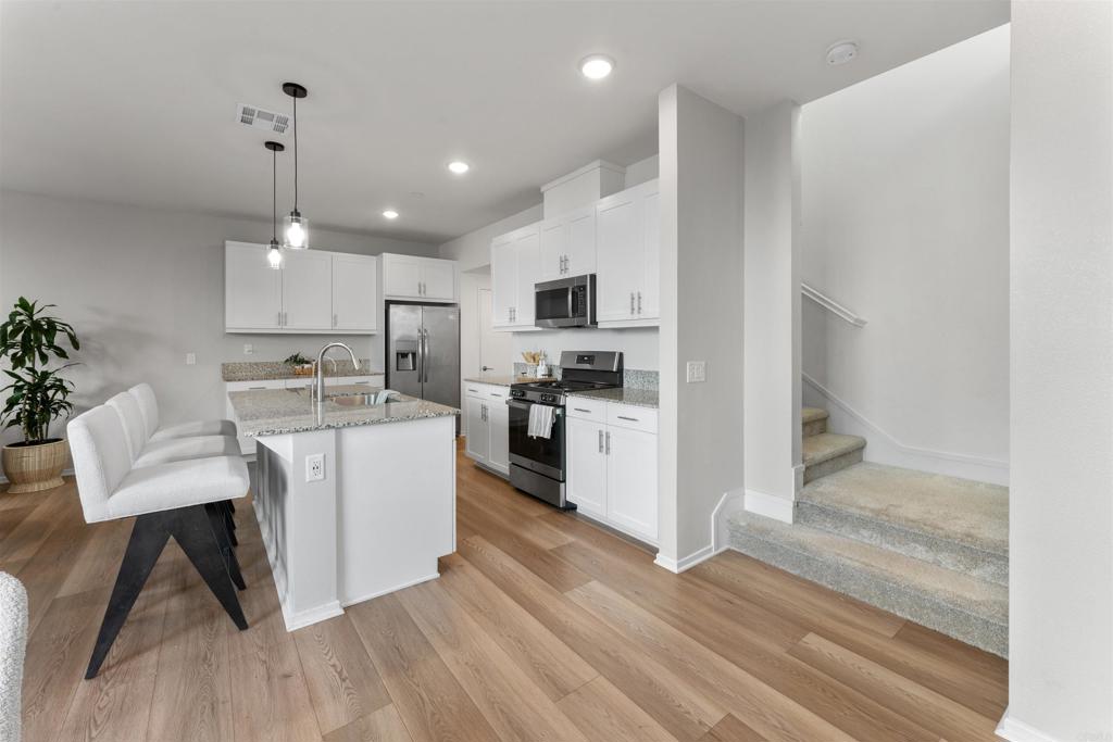 212 Perennial Place Fallbrook, CA 92028 - Photo 12 of 39 a kitchen with kitchen island white cabinets and stainless steel appliances