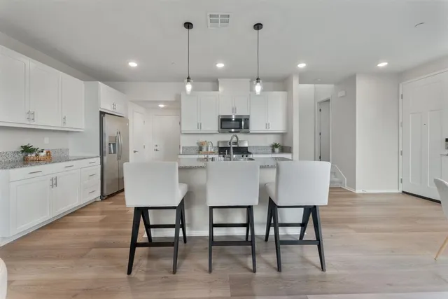 a kitchen with kitchen island a table and chairs in it