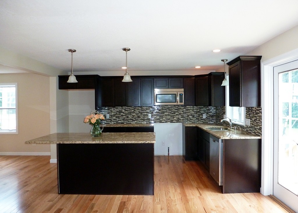 184 Ellsworth Avenue Springfield, MA 01118 - Photo 6 of 25 a kitchen with stainless steel appliances kitchen island granite countertop a stove and a wooden floors