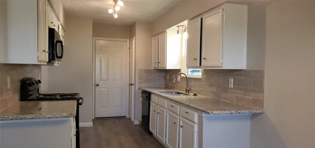 a kitchen with stainless steel appliances granite countertop a sink stove and cabinets