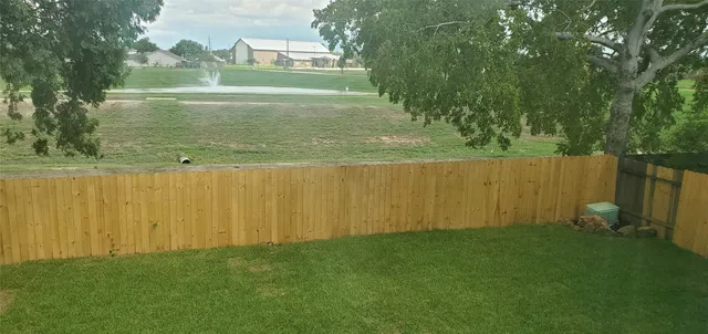 a view of yard with swimming pool and green space