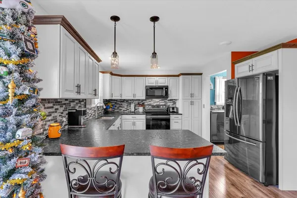 a kitchen with stainless steel appliances granite countertop a refrigerator a stove and a sink