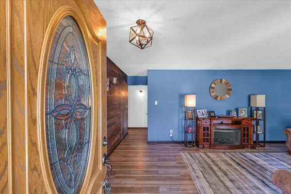 a view of a hallway with wooden floor and furniture