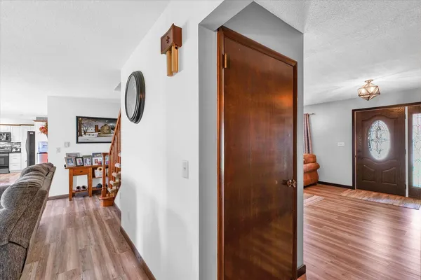 a view of a hallway with wooden floor and dining room