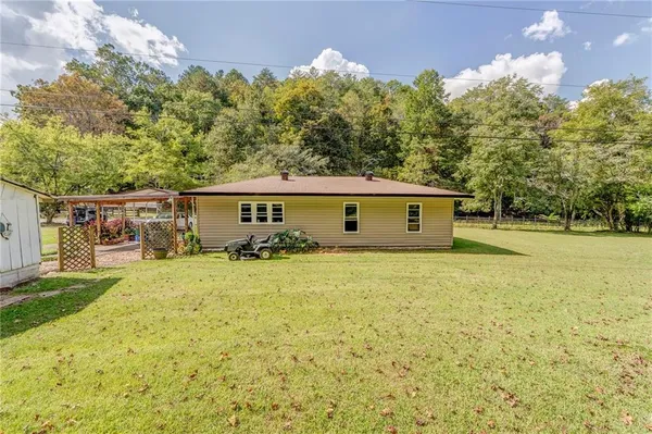a view of a house with backyard and trees