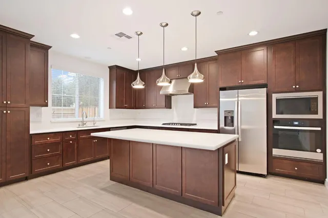 large kitchen with stainless steel appliances granite countertop wooden cabinets a sink and a stove