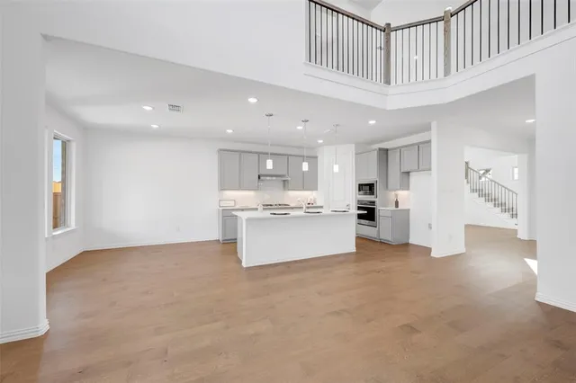 a large white kitchen with kitchen island a sink a center island stainless steel appliances and a cabinets