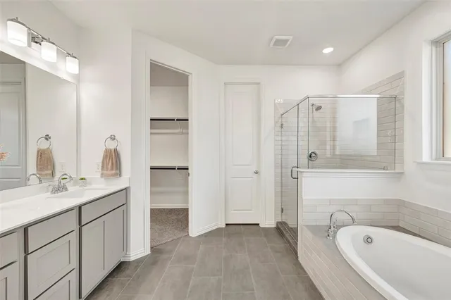 a spacious bathroom with a tub sink and mirror