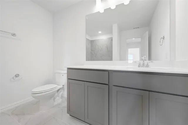 a bathroom with a sink a toilet and mirror