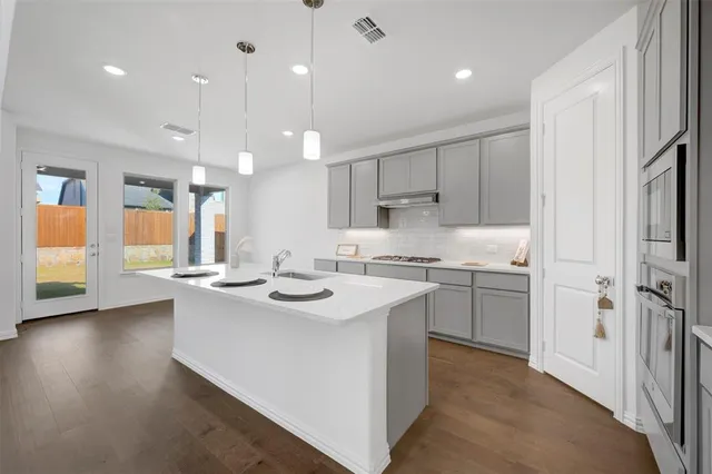 a kitchen with a sink a window and stainless steel appliances