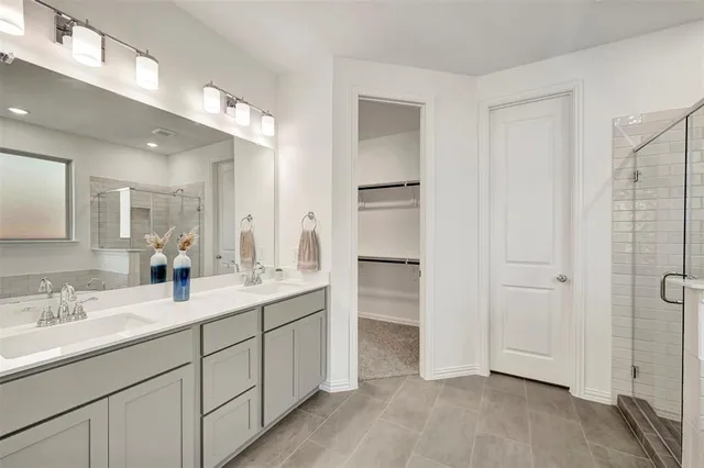 a bathroom with a double vanity sink a mirror and a shower