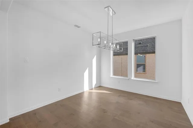 a view of an empty room with chandelier and window