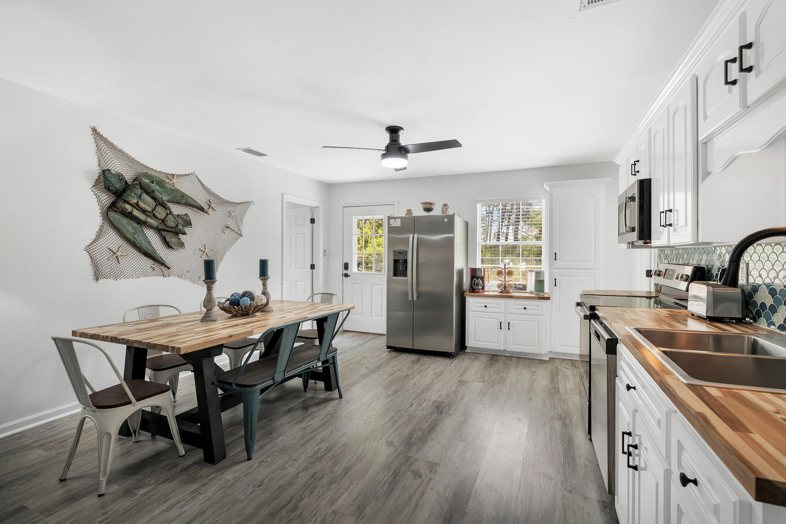 481 North Orange Street Inlet Beach, FL 32461 - Photo 11 of 57 a kitchen with stainless steel appliances granite countertop a sink dishwasher a stove a refrigerator with a dining table and chairs with wooden floor