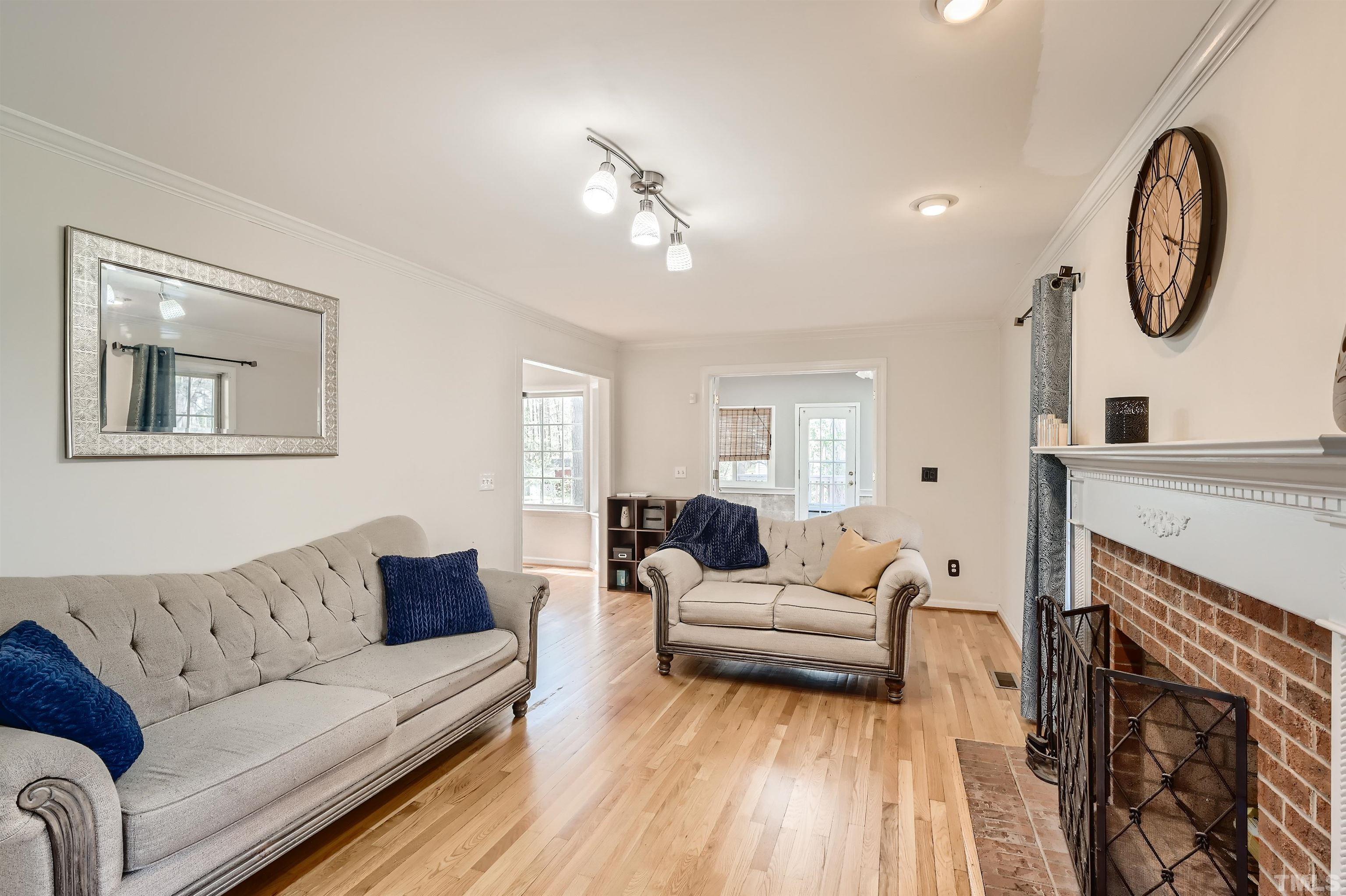 1705 Reynolda Court Raleigh, NC 27603 - Photo 7 of 28 a living room with furniture a fireplace and a chandelier